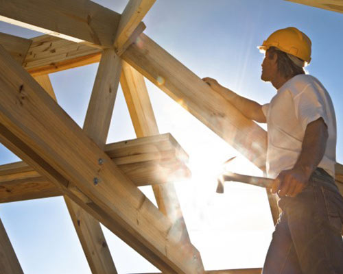 a construction worker building the frame of a house