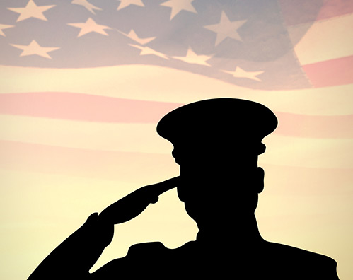 Armed service man saluting the American Flag